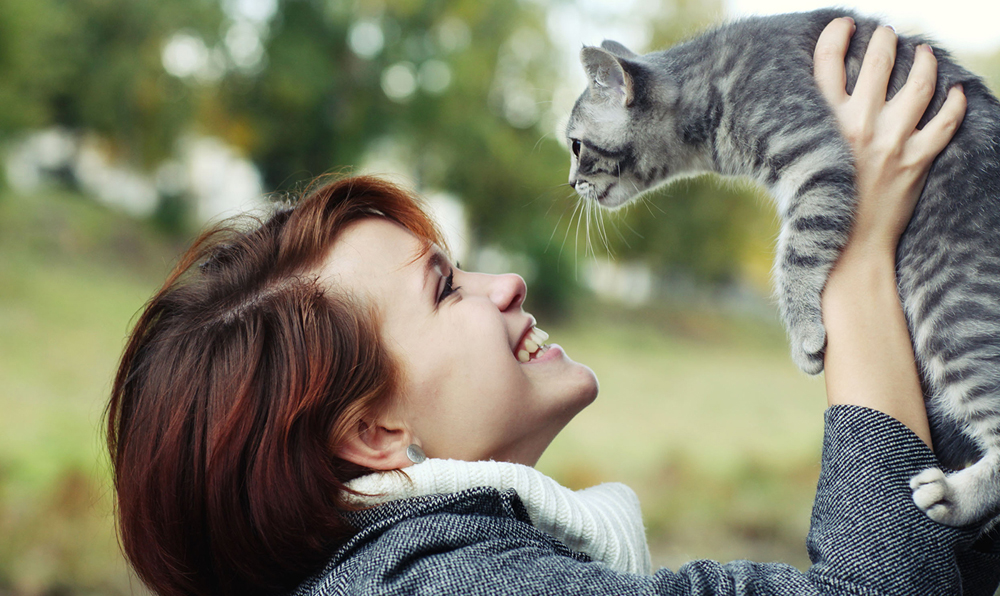 a woman holding her cat in the air